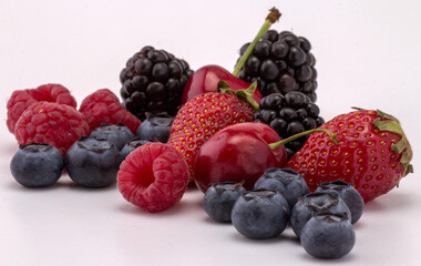 Himbeeren, Heidelbeeren, Brombeeren und Kirschen auf einer gerade Fläche ausgebreitet
