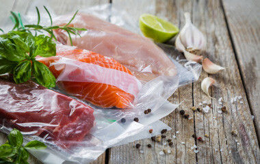 Lachs, Steak, Hühnchen einvakuumiert auf einem Tisch liegend