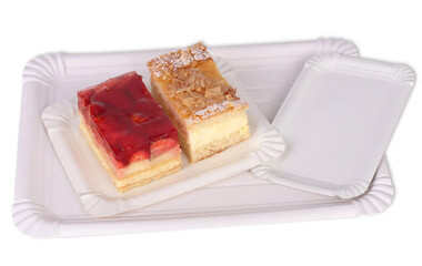 Eine große Tortenunterlage mit kleinen darauf. Auf der kleinen Tortenunterlage sind zwei Stückchen Kuchen abgestellt
