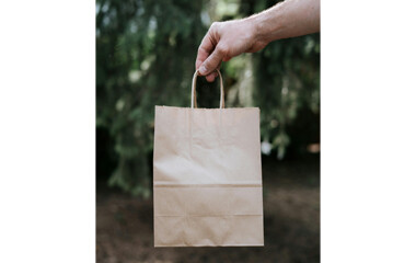 Braune Papiertragetasche wird von einer Hand gehalten