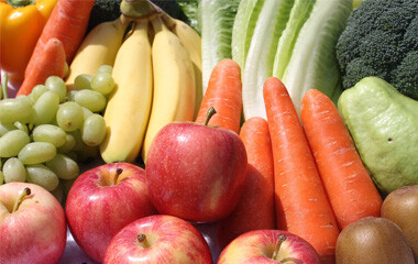 Viele verschiedene Obst und Gemüse Sorten nebeneinander gereiht. Bannanen, Karotten, Trauben, Apfel, Kiwi, etc.